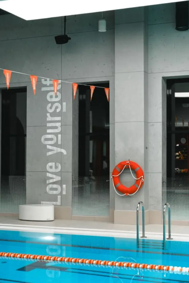 Une bouée de sauvetage suspendue près d'un bassin de piscine intérieure.